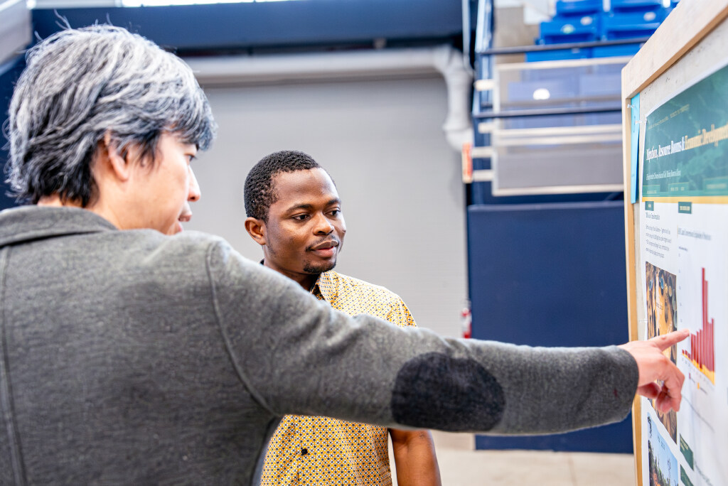 two people looking and pointing at board