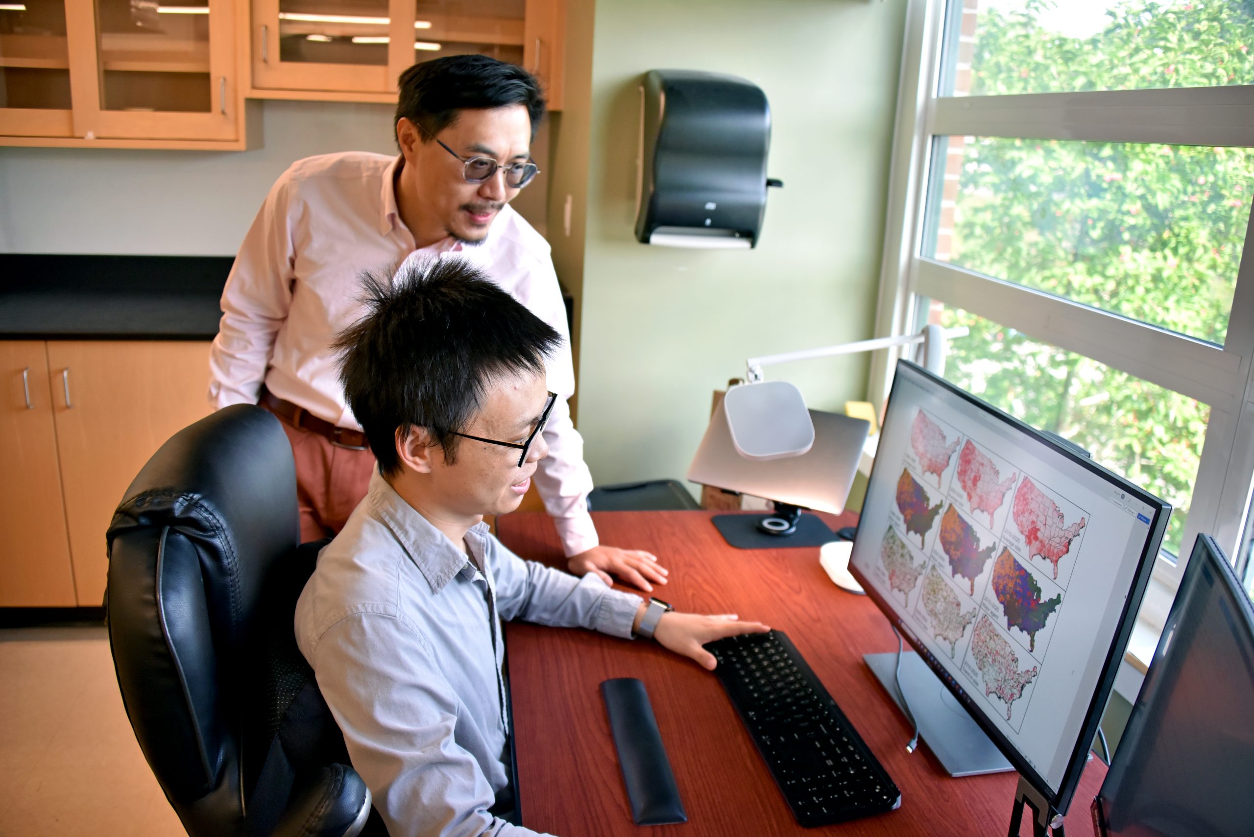 Two people looking at a computer with heatmaps